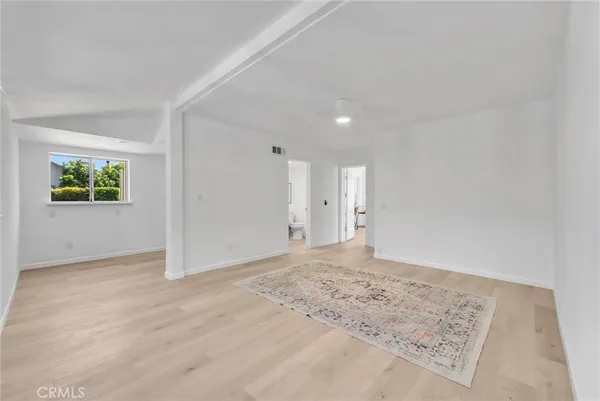 an empty room with window and wooden floor