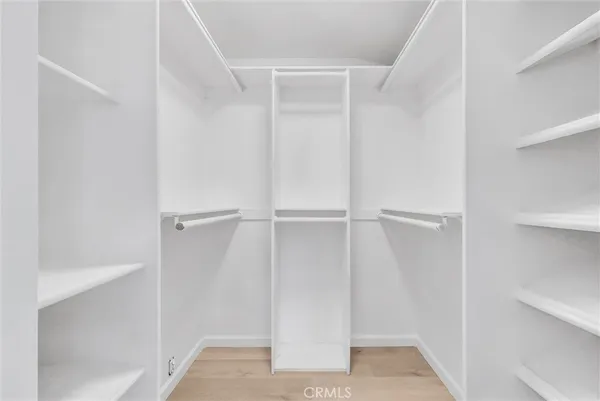 a view of walk in closet with empty racks