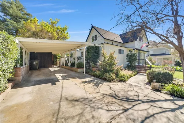 a front view of a house with a yard and potted plants