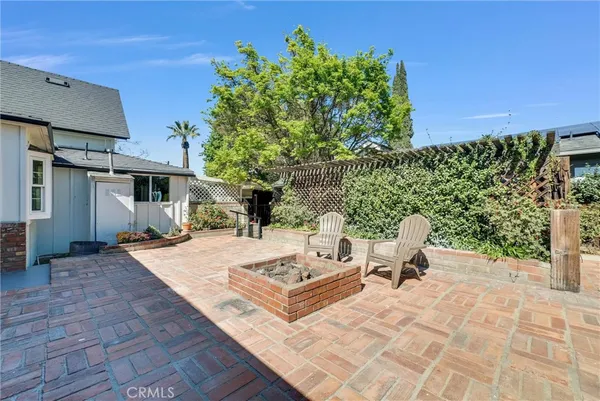 a view of a patio with table and chairs with wooden floor and fence