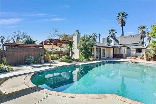 a front view of a house with swimming pool having outdoor seating