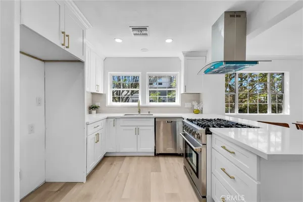 a kitchen with granite countertop a sink stove and cabinets