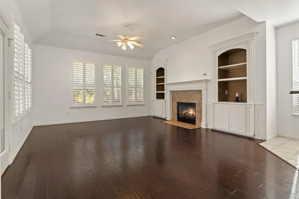 an empty room with windows and fireplace