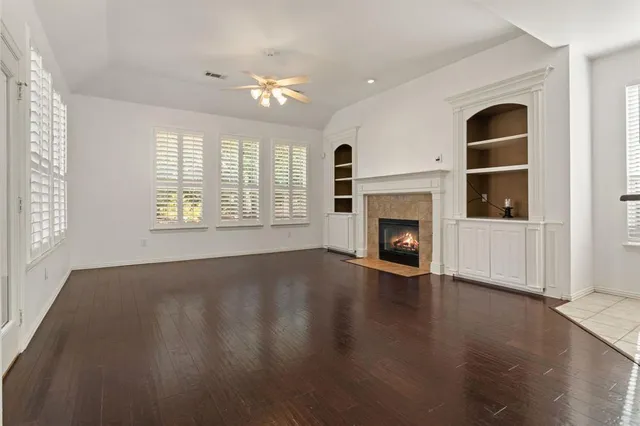 an empty room with windows and fireplace