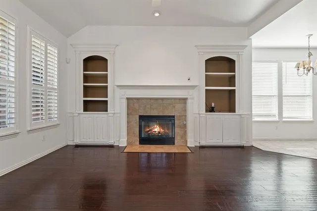 a view of an empty room with exposed radiator and fireplace