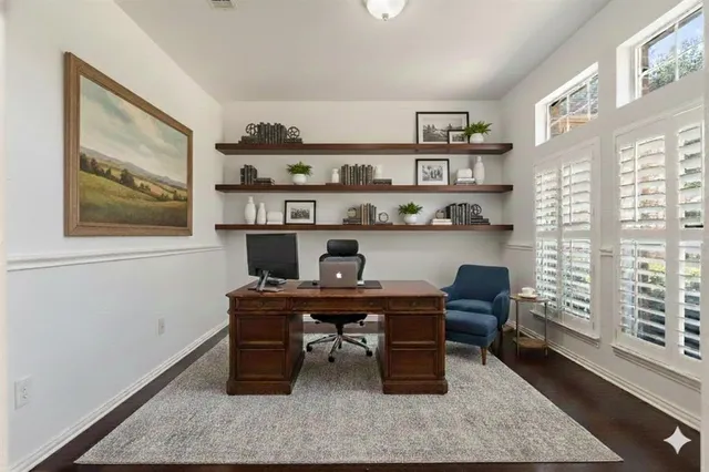 a view of a workspace with furniture and a window