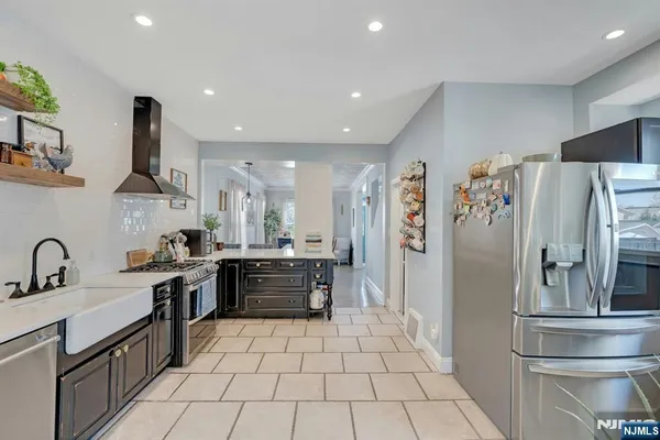 a kitchen with stainless steel appliances a refrigerator sink and stove