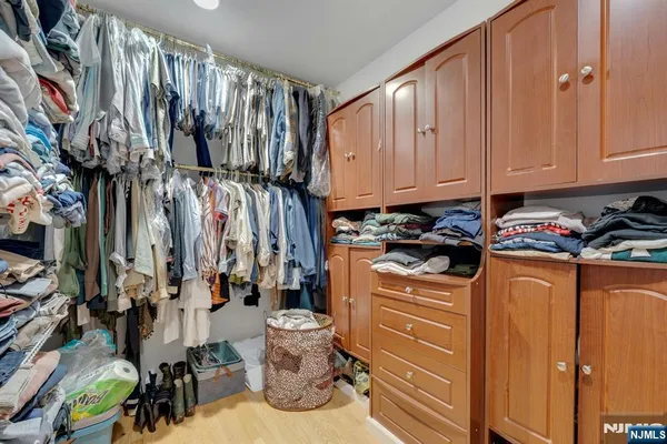 a view of walk in closet with clothes and shoes