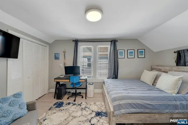 a bedroom with a bed and a computer on the desk