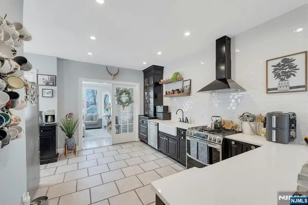 a kitchen with stainless steel appliances a stove a sink a refrigerator a counter top space and cabinets