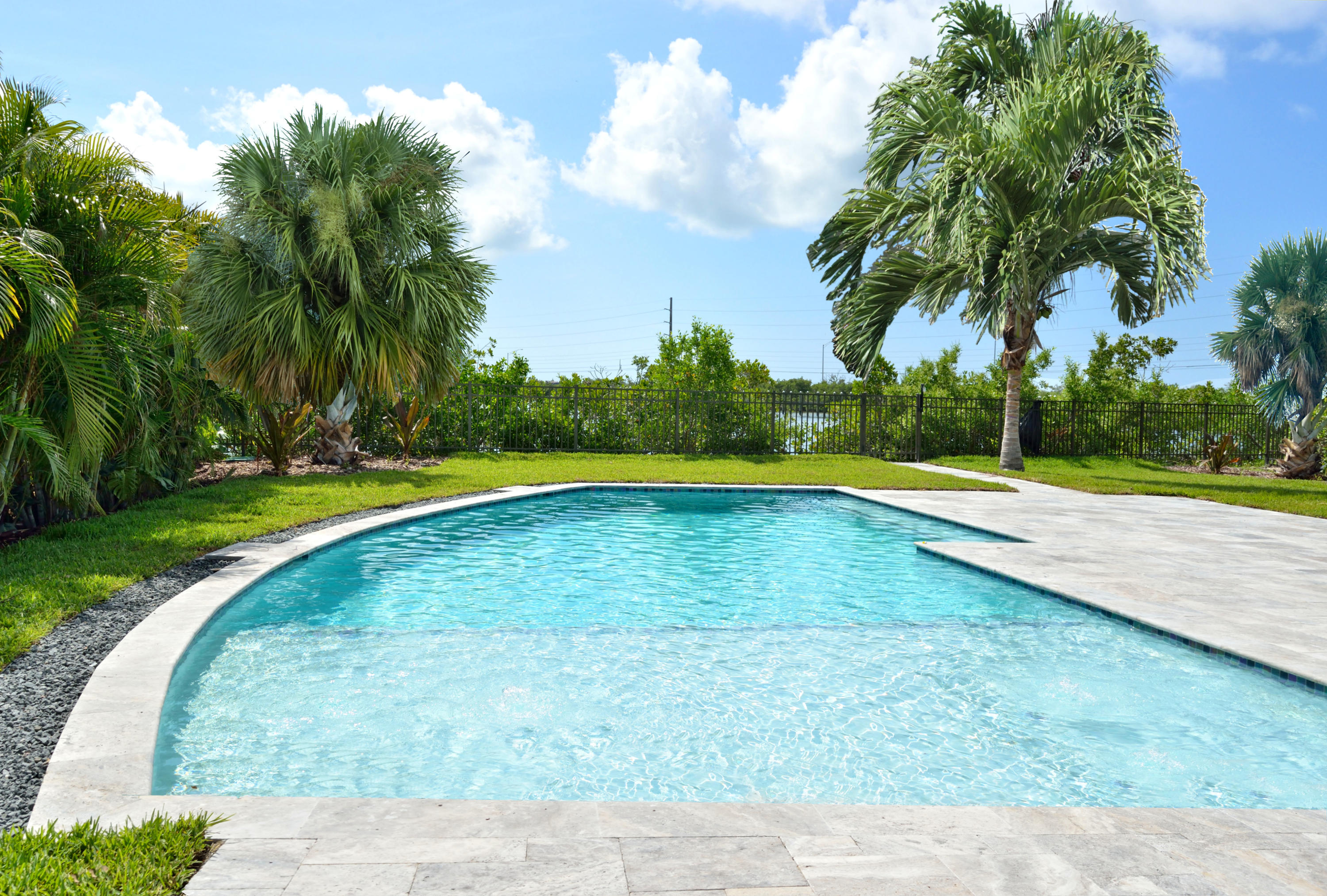 37 Key Haven Road Key West, FL 33040 - Photo 8 of 9 a view of a swimming pool with a yard and palm trees