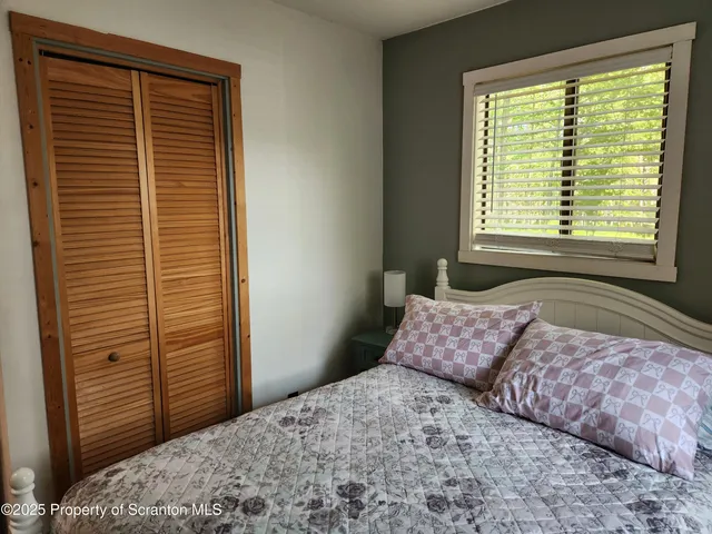 a bedroom with a bed and flat screen tv