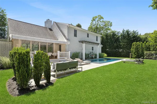 a view of a house with backyard sitting area and garden