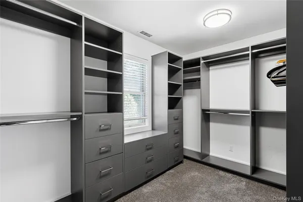 a view of walk in closet with empty racks