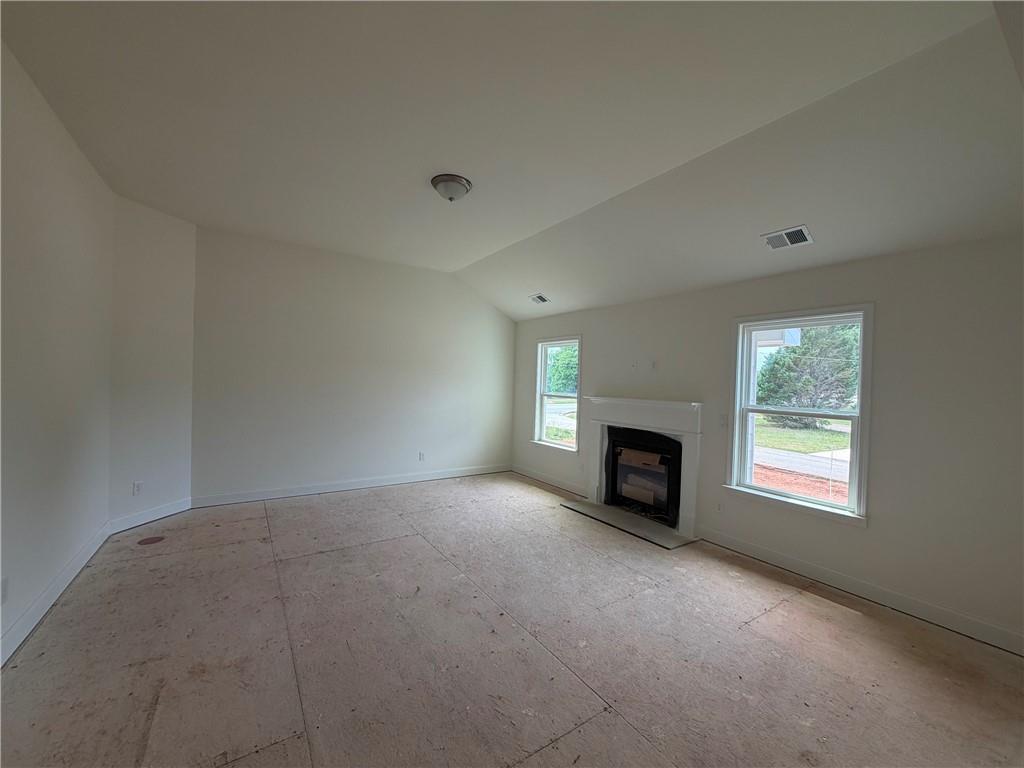 41 Woodland Road Covington, GA 30016 - Photo 11 of 46 an empty room with fireplace and windows