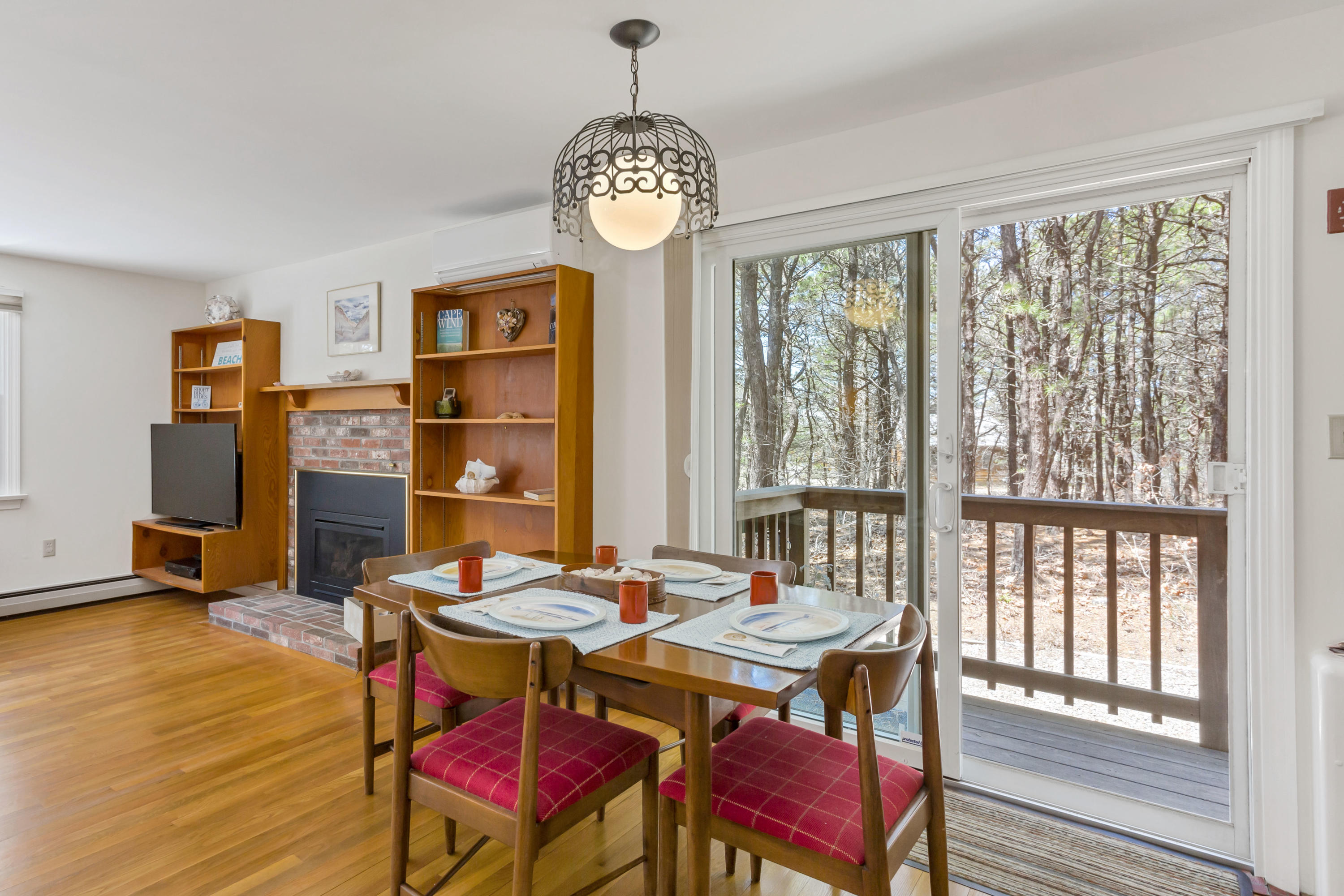 140 Salt Works Road Eastham, MA 02642 - Photo 19 of 49 a view of a dining room with furniture a chandelier and wooden floor
