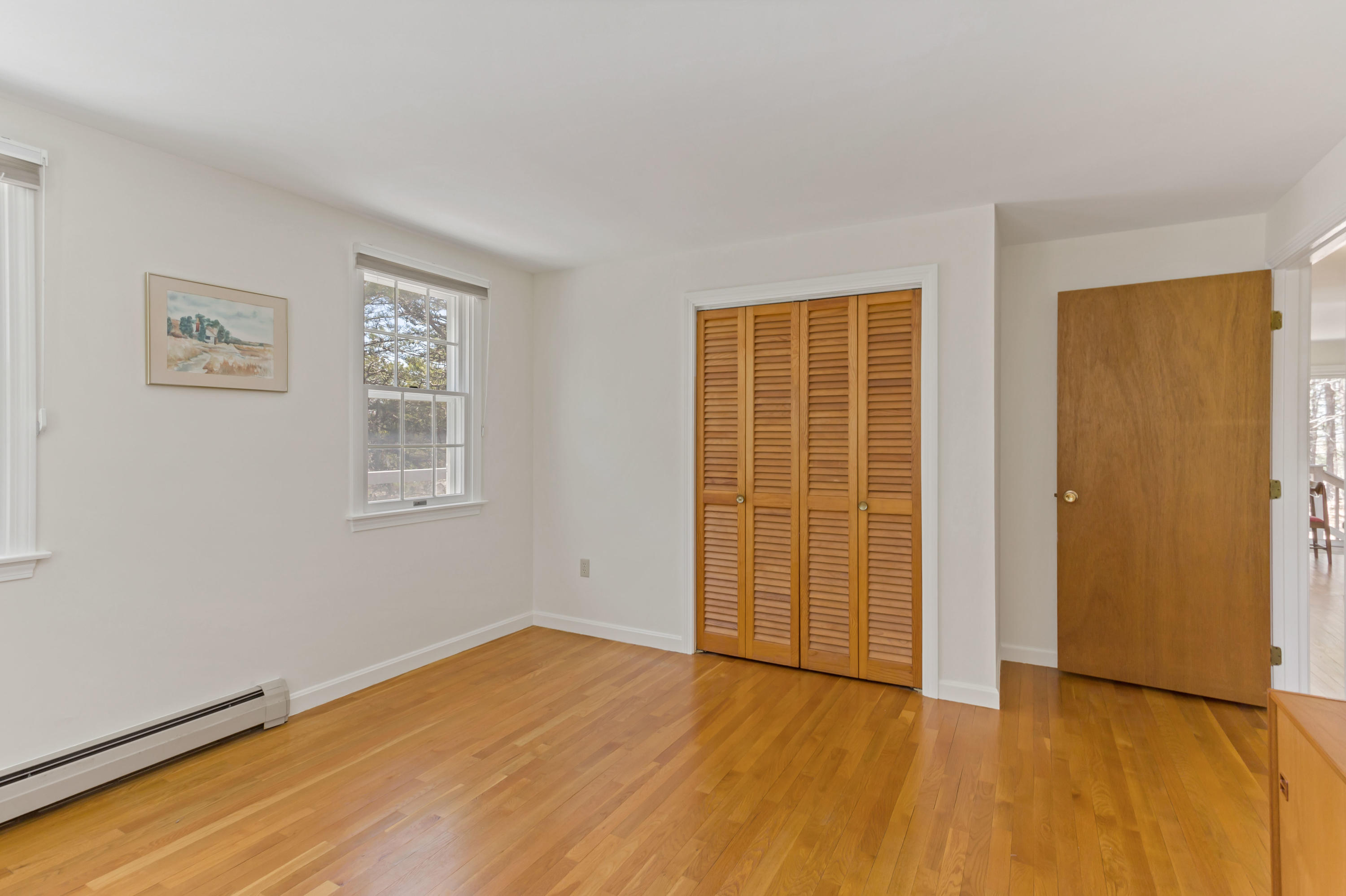 140 Salt Works Road Eastham, MA 02642 - Photo 23 of 49 a view of an empty room with wooden floor and a window