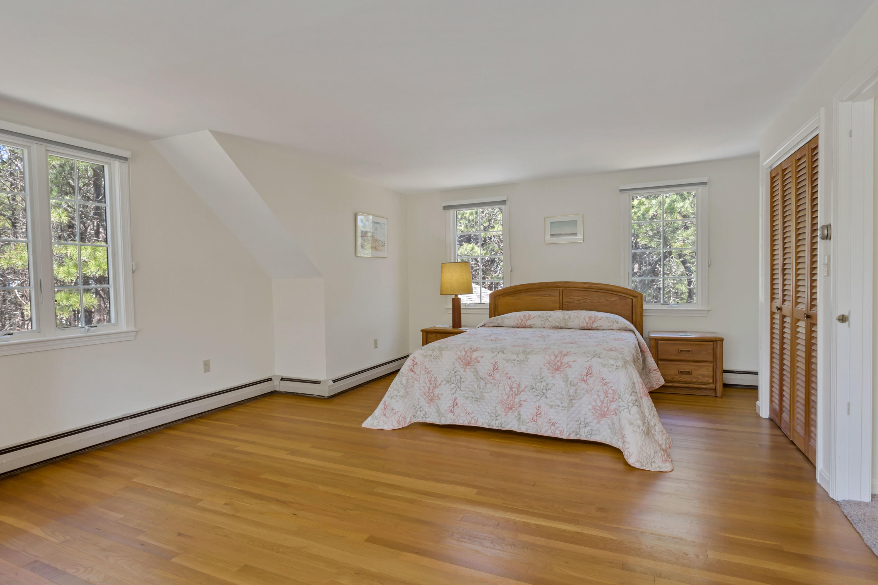 140 Salt Works Road Eastham, MA 02642 - Photo 32 of 49 a bedroom with a bed and wooden floor