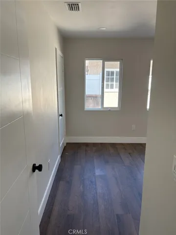 a view of a room with wooden floor and window