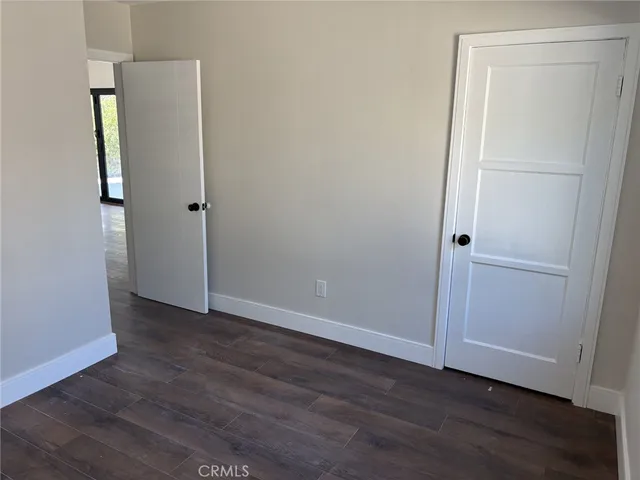 an empty room with wooden floor and closet