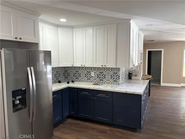 a kitchen with stainless steel appliances granite countertop a refrigerator and a stove