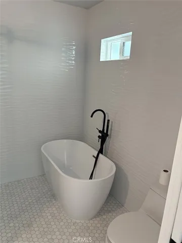 a white tub sitting next to a toilet