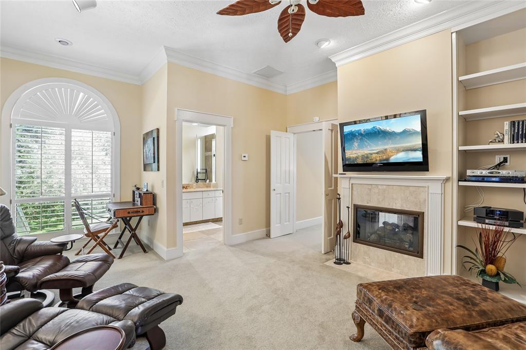 17810 Crawley Road Odessa, FL 33556 - Photo 35 of 76 a living room with furniture flat screen tv and a fireplace