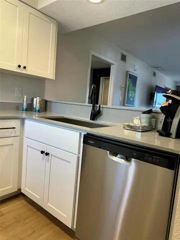 a kitchen with cabinets stainless steel appliances and a wooden floor