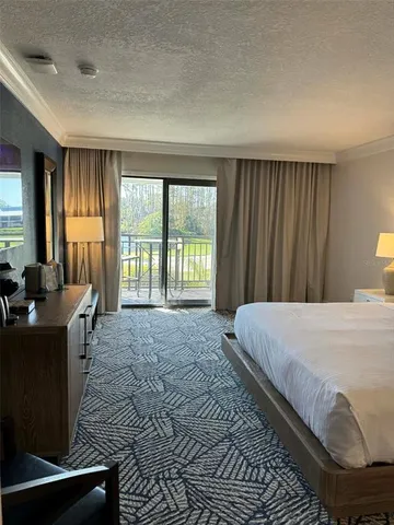 a bed sitting in a spacious bedroom next to a window