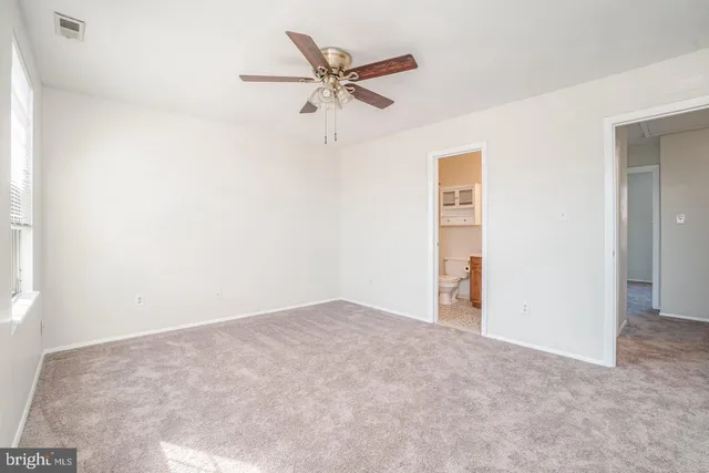 an empty room with closet and ceiling fan