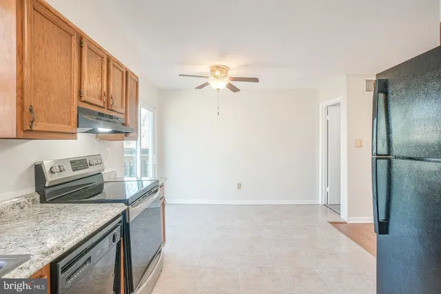 a kitchen with stainless steel appliances granite countertop a refrigerator a stove a sink and dishwasher