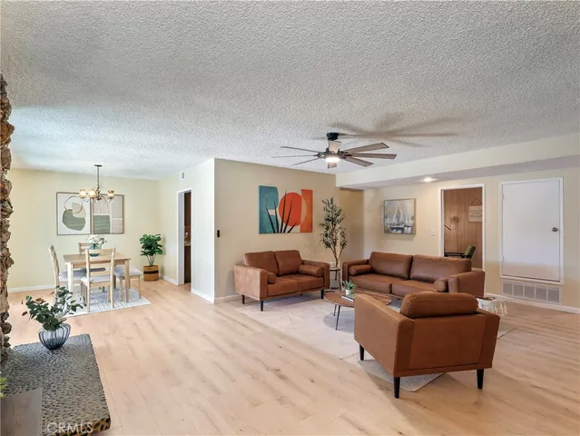 a dining room with furniture a chandelier and wooden floor