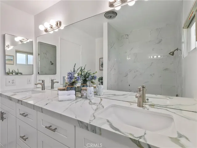 a bathroom with double vanity sinks and a mirror