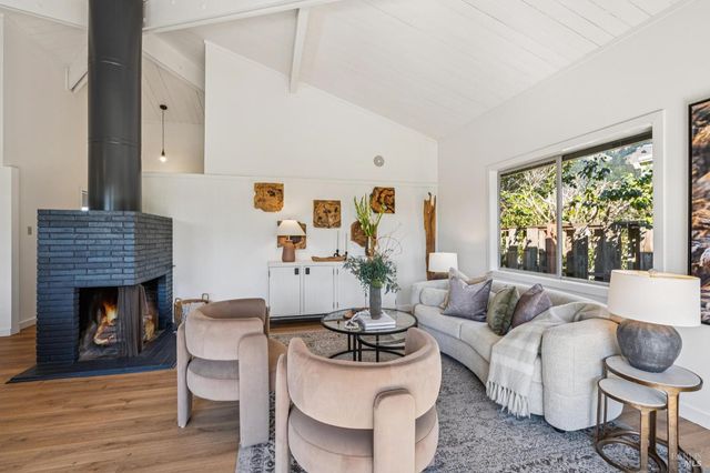 a living room with furniture a fireplace and a large window
