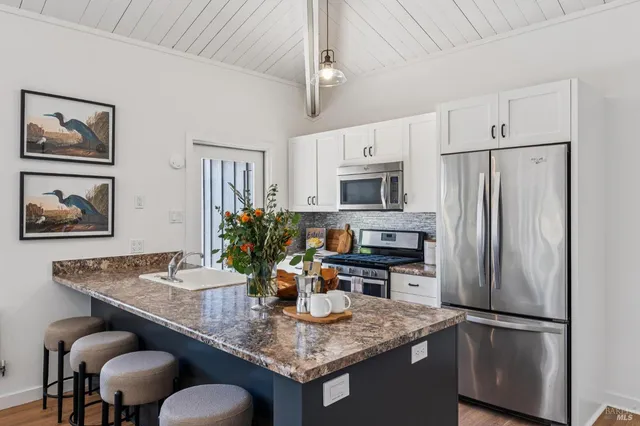 a kitchen with stainless steel appliances granite countertop a sink refrigerator and microwave