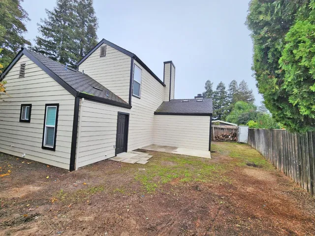 a view of a small house with wooden fence