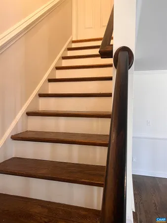 an empty room with wooden floor fireplace and windows