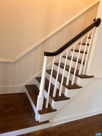 a view of a hallway with wooden floor and staircase