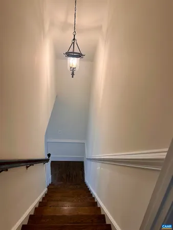 a view of an empty room with wooden floor and windows