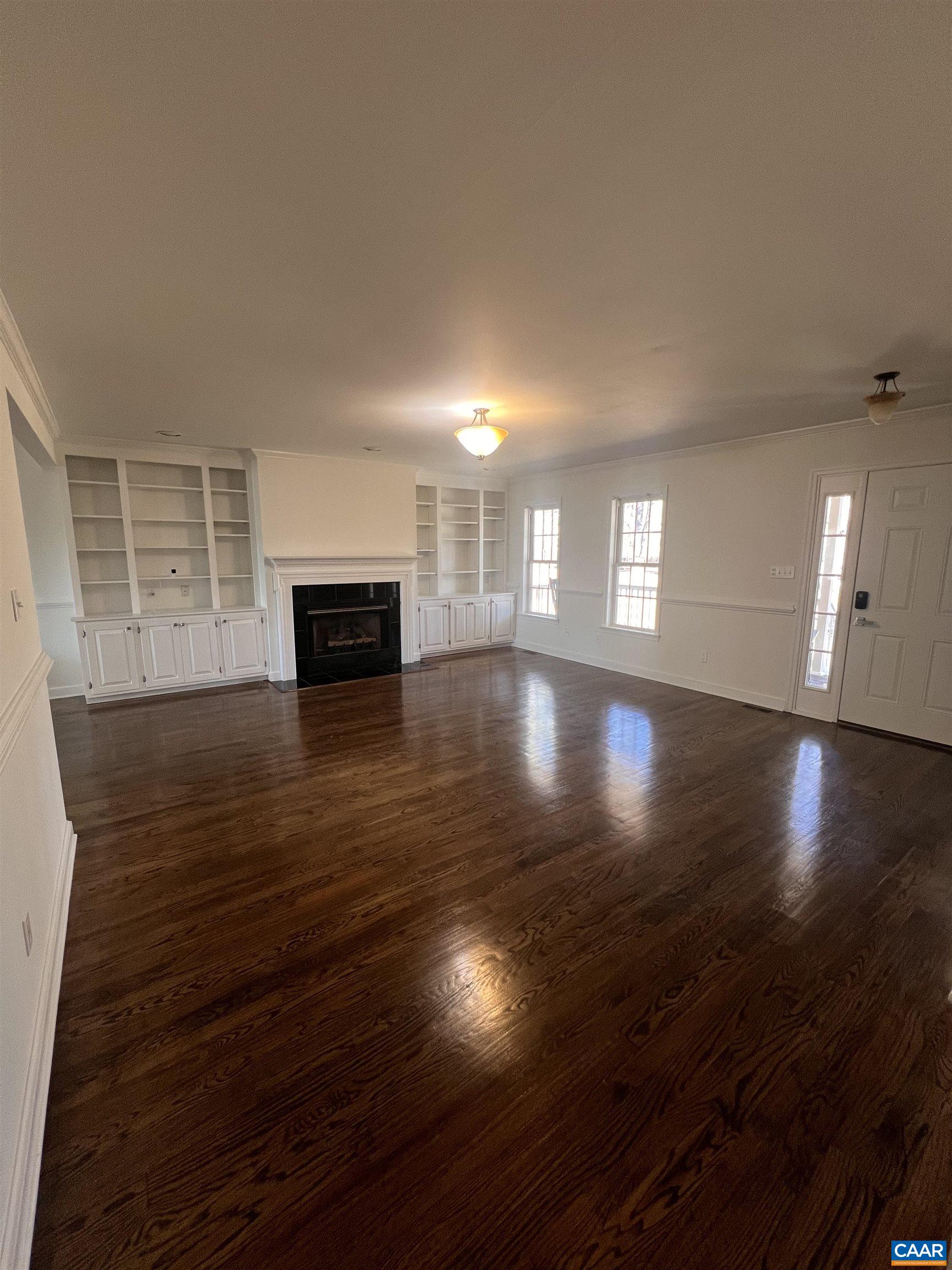 651 Kents Mill Road Louisa, VA 23093 - Photo 39 of 55 an empty room with wooden floor fireplace and windows