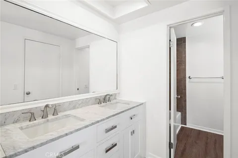 a bathroom with a granite countertop sink a toilet a shower and a mirror