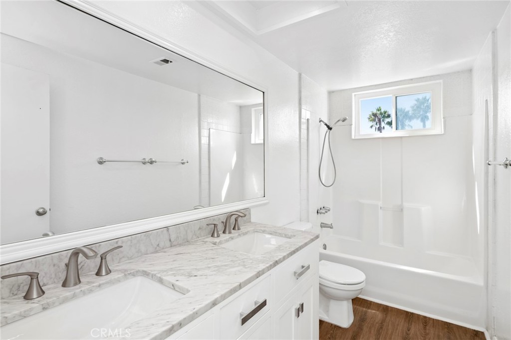 203 Cedar Street, Unit A & B Newport Beach, CA 92663 - Photo 25 of 32 a bathroom with a granite countertop sink a toilet a shower and a mirror