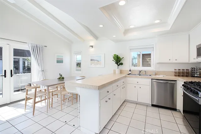 a kitchen with white cabinets and appliances