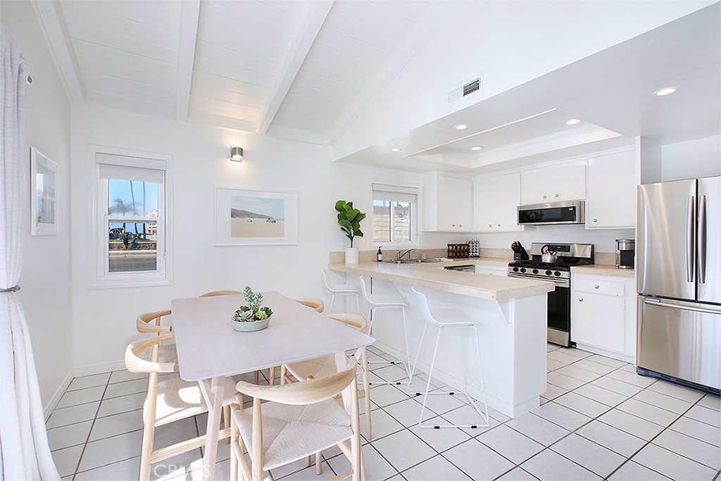 203 Cedar Street, Unit A & B Newport Beach, CA 92663 - Photo 5 of 32 a kitchen with stainless steel appliances kitchen island granite countertop a refrigerator and a stove top oven