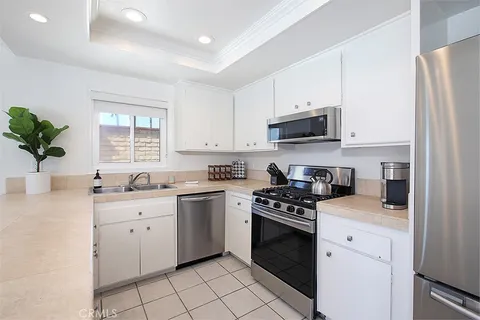 a kitchen with white cabinets and appliances