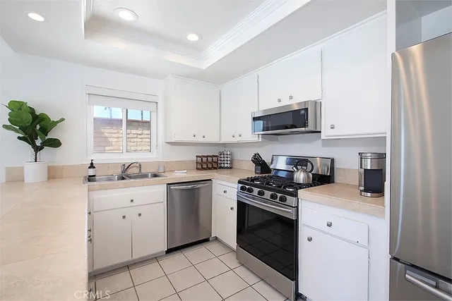 a kitchen with white cabinets and appliances