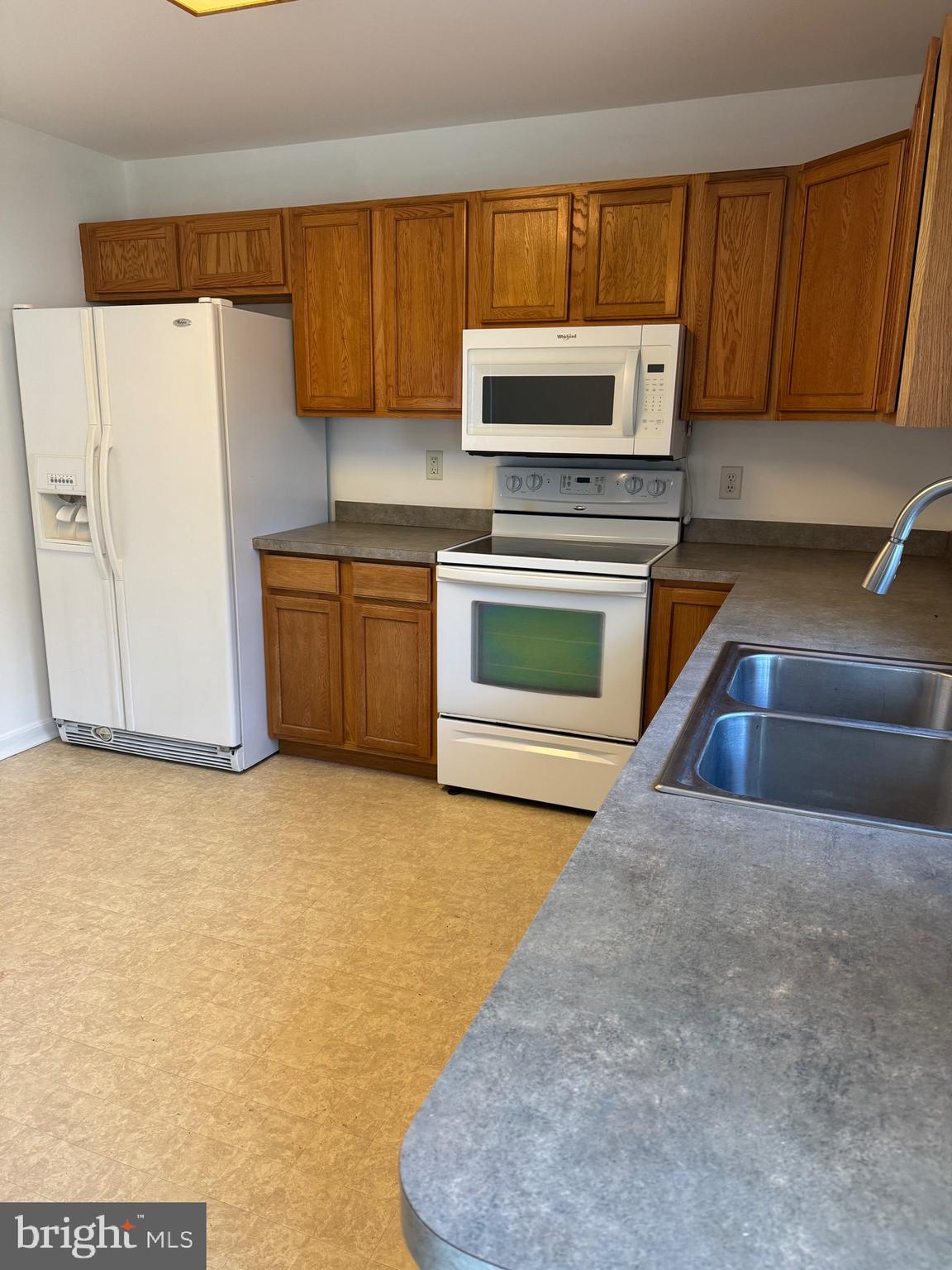 113 Boyce Mill Road Greensboro, MD 21639 - Photo 13 of 23 a kitchen with granite countertop a stove a microwave a sink and cabinets