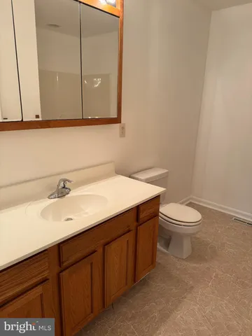 a bathroom with a granite countertop sink a toilet and a mirror