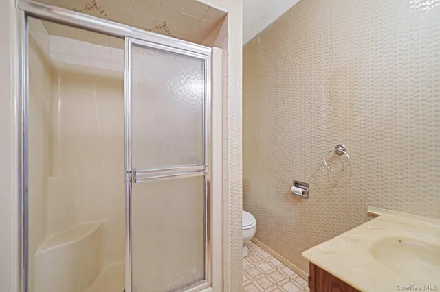 a bathroom with a sink and mirror with toilet