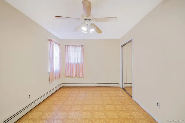 an empty room with an entryway and chandelier fan